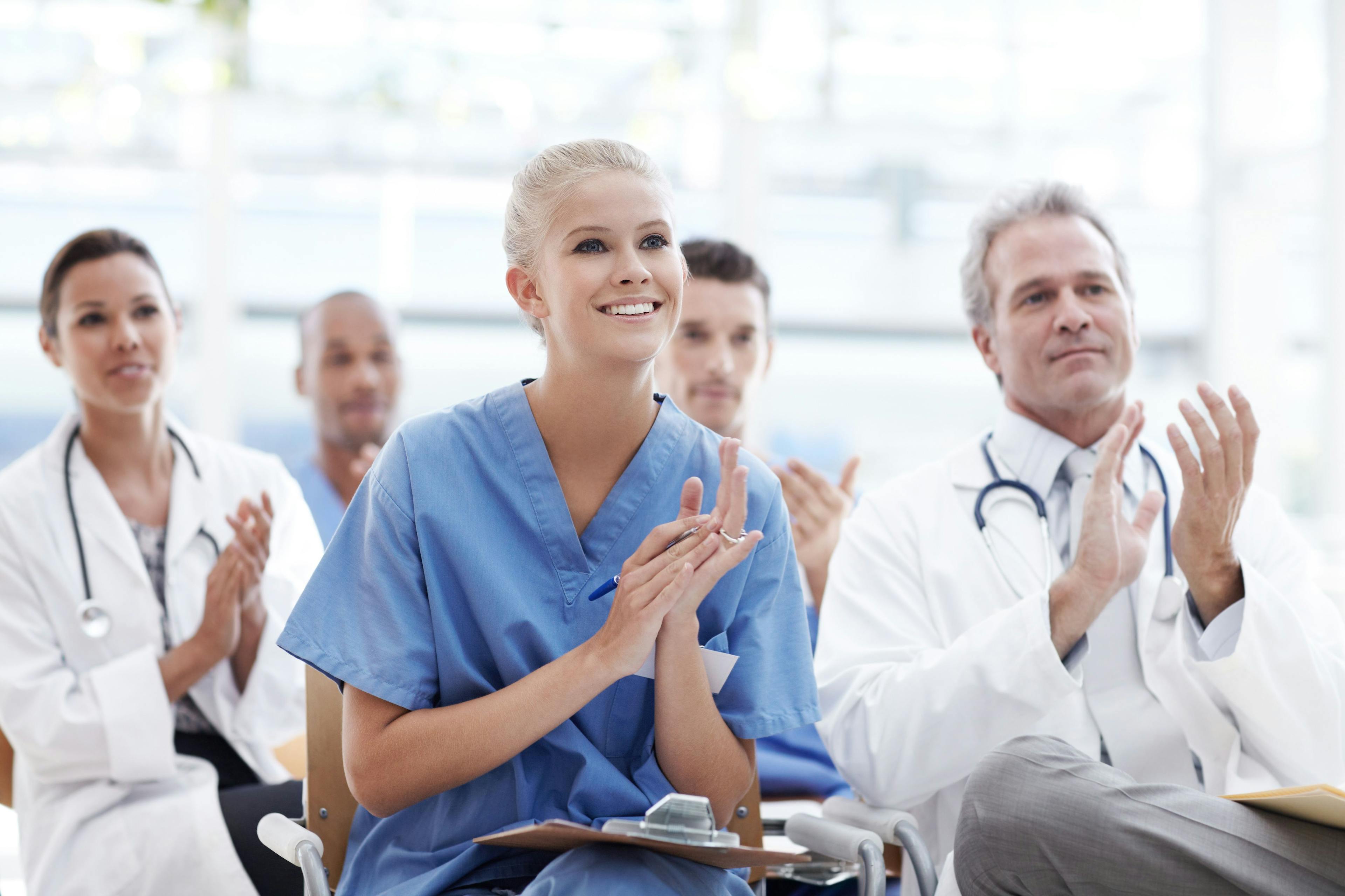 Celebrating breakthroughs in health care. Doctors and nurses applauding their lecturer: © Stigur/people.images.com - stock.adobe.com